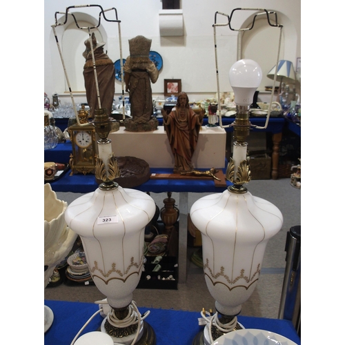 323 - A pair of white glass table lamps with gilt decoration and brass fittings