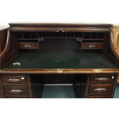 36 - An early 20th century stained oak roll top desk with tambour topped writing compartment concealing f... 