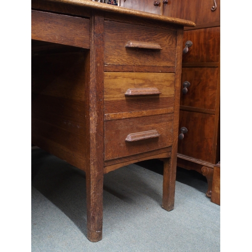 46 - An early 20th century oak clerks desk with sloped writing top over single central drawer flanked by ... 