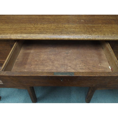 46 - An early 20th century oak clerks desk with sloped writing top over single central drawer flanked by ... 