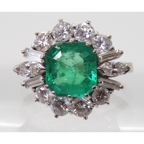 2750 - AN EMERALD & DIAMOND CLUSTER RINGset with a step cut emerald of approx 8.95mm x 8.33mm x 4.6mm i... 