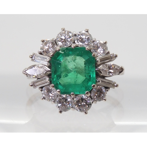 2750 - AN EMERALD & DIAMOND CLUSTER RINGset with a step cut emerald of approx 8.95mm x 8.33mm x 4.6mm i... 