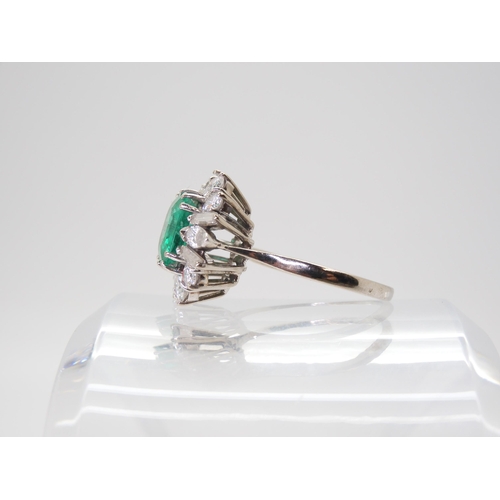 2750 - AN EMERALD & DIAMOND CLUSTER RINGset with a step cut emerald of approx 8.95mm x 8.33mm x 4.6mm i... 