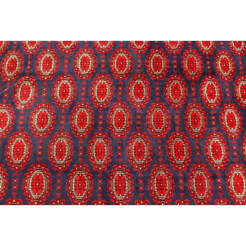 2137 - A DARK BLUE GROUND TURKMAN RUGwith all-over geometric lozenge design and multicolour geometric borde... 