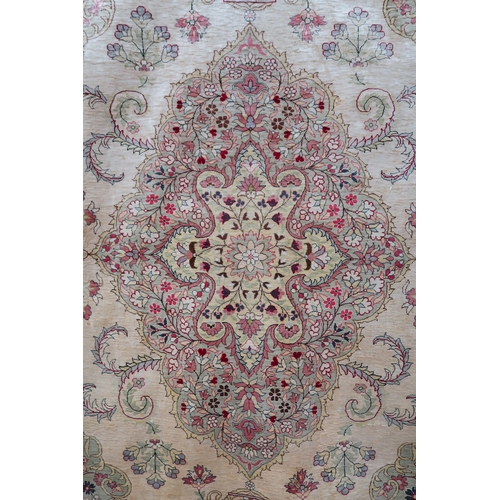 106 - A beige ground Keshan rug with multicolour floral central medallion, matching spandrels and flower h... 