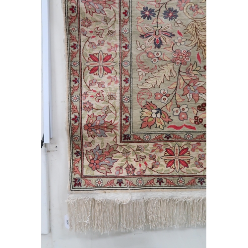 106 - A beige ground Keshan rug with multicolour floral central medallion, matching spandrels and flower h... 