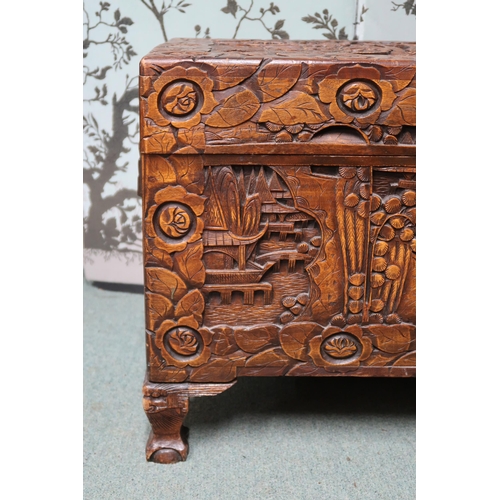 21 - A 20th century Oriental carved camphorwood chest with internal tray on clawed feet, 51cm high x 93cm... 