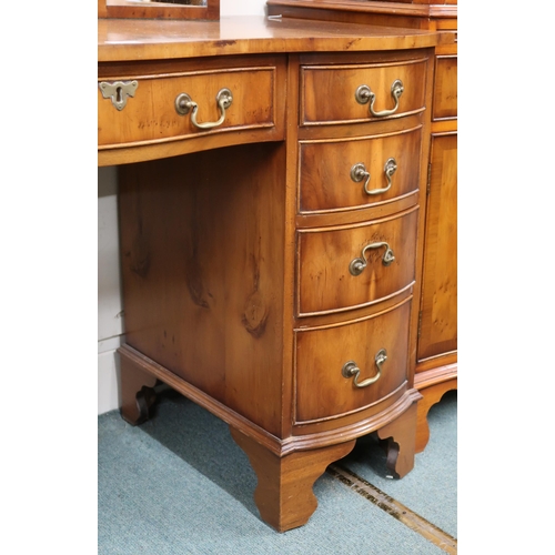 35 - A 20th century reproduction serpentine front dressing table with triple plate dressing mirror over c... 