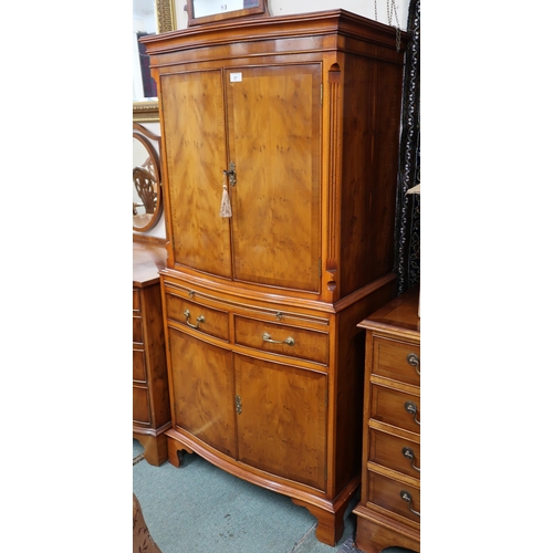 37 - A 20th century walnut veneered serpentine front drinks cabinet with pair of cabinet doors concealing... 