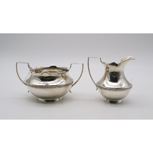 385 - A silver cream jug and sugar bowl, by Wilmot Manufacturing Co, Birmingham 1927, with banded floral d... 