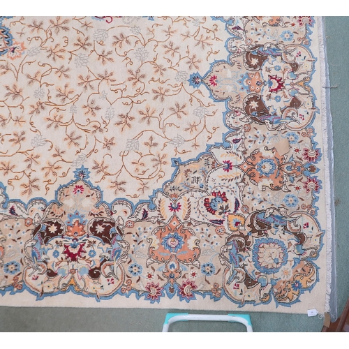 53 - A beige floral patterned ground Tabriz rug with multicoloured central medallion and matching borders... 