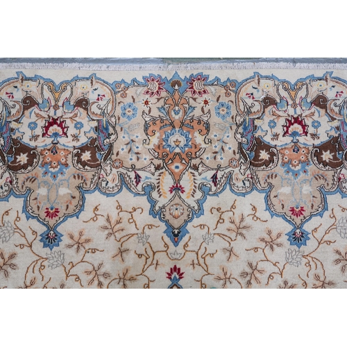 53 - A beige floral patterned ground Tabriz rug with multicoloured central medallion and matching borders... 