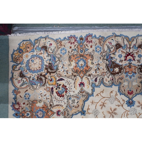 53 - A beige floral patterned ground Tabriz rug with multicoloured central medallion and matching borders... 