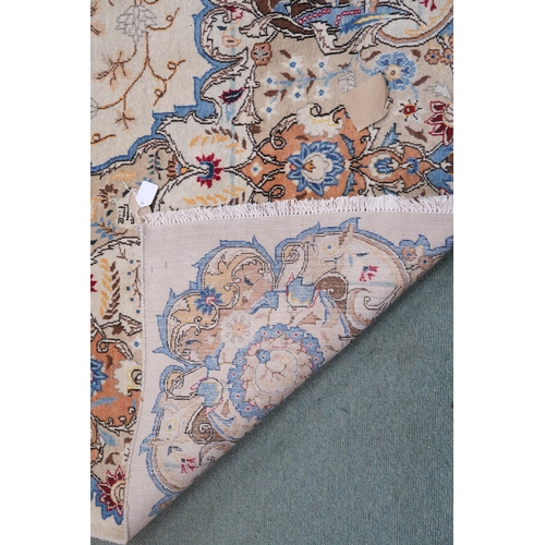 53 - A beige floral patterned ground Tabriz rug with multicoloured central medallion and matching borders... 