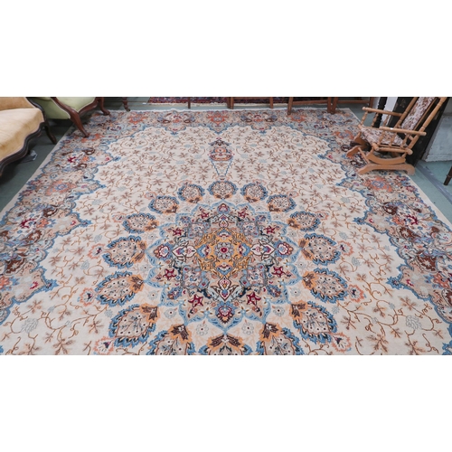 53 - A beige floral patterned ground Tabriz rug with multicoloured central medallion and matching borders... 