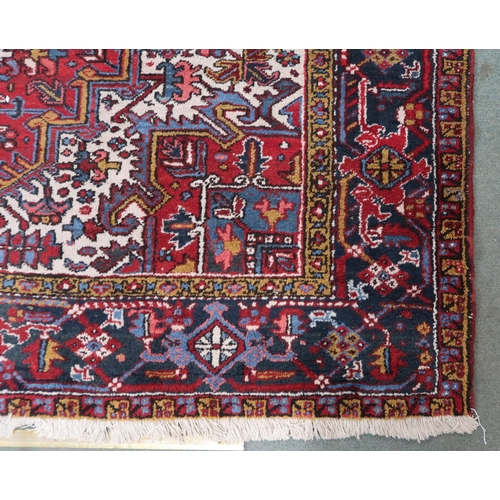 54 - A red geometric patterned ground Belouch rug with dark blue and white geometric central medallion, w... 