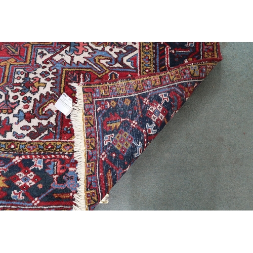 54 - A red geometric patterned ground Belouch rug with dark blue and white geometric central medallion, w... 