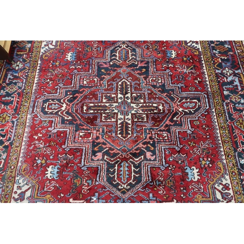 54 - A red geometric patterned ground Belouch rug with dark blue and white geometric central medallion, w... 