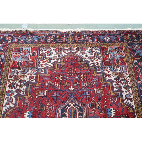 54 - A red geometric patterned ground Belouch rug with dark blue and white geometric central medallion, w... 