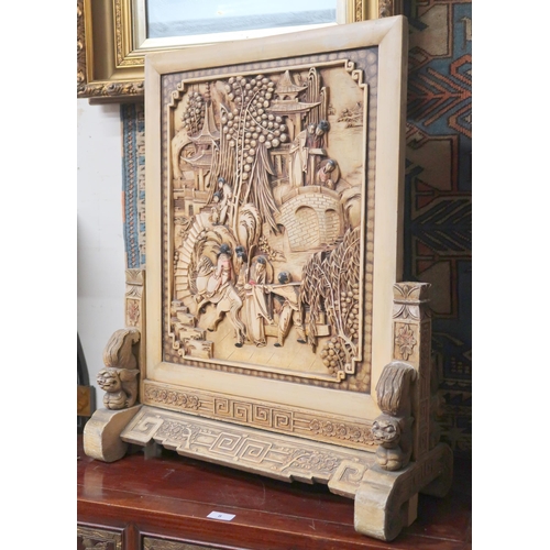 7 - An early 20th century Chinese table screen carved with village scene on carved supports joined by ca... 