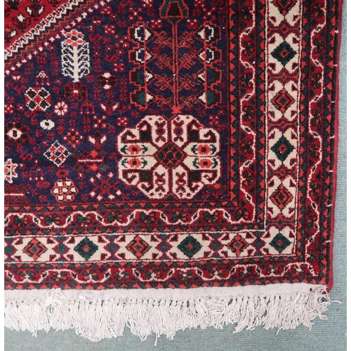 78 - A red ground Balouch rug with cream geometric central medallion, dark blue spandrels and cream borde... 