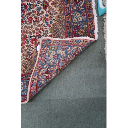 80 - A cream floral pattern ground Keshan rug with light blue central medallion, blue spandrels and light... 