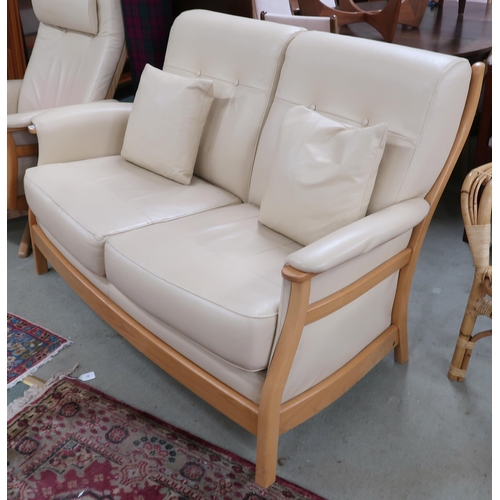 82 - A contemporary elm and beech framed Ercol Gina two seater sofa with cream leather upholstery, 94cm h... 