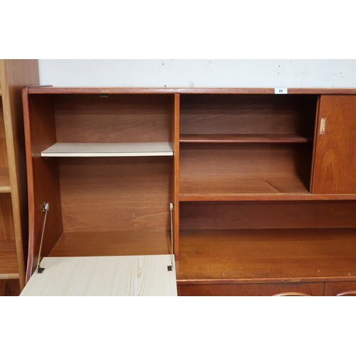 89 - A mid 20th century teak Jentique sideboard with fall front compartment alongside sliding doors over ... 