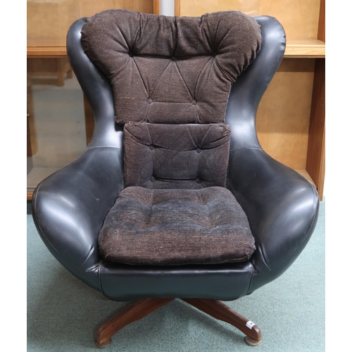 94 - A mid 20th century black vinyl upholstered revolving chair in the manner of Arne Jacobsen, 93cm high... 