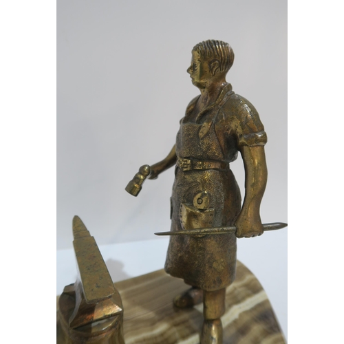 236 - A gilded spelter figure of a blacksmith on banded stone base