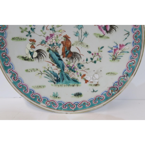 249A - A Chinese Famille rose plate, decorated with roosters amongst flowers and foliage, surrounded by a b... 