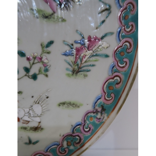 249A - A Chinese Famille rose plate, decorated with roosters amongst flowers and foliage, surrounded by a b... 