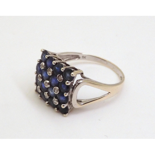 714 - A 9ct white gold sapphire and diamond accent cluster ring, size O1/2, weight 3.1gms