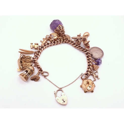 731 - A 9ct gold charm bracelet with Two 18k charms, thirteen 9ct charms, five yellow metal charms and a s... 