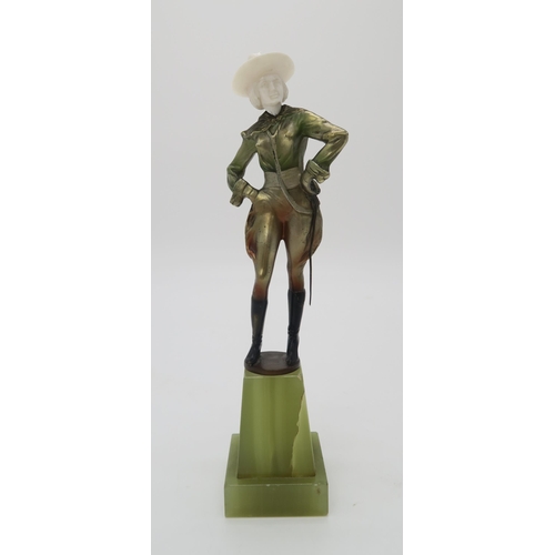 2220 - A PATINATED BRONZE AND IVORY ART DECO FIGURE OF A COWGIRLpossibly by Joseph Lorenzl, standing with h... 