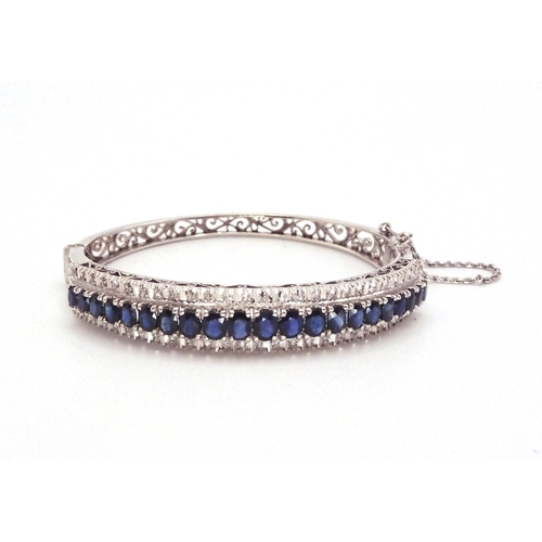 2702 - A SAPPHIRE AND DIAMOND BRACELET in 18k white gold set with twenty one oval sapphires tapering i... 