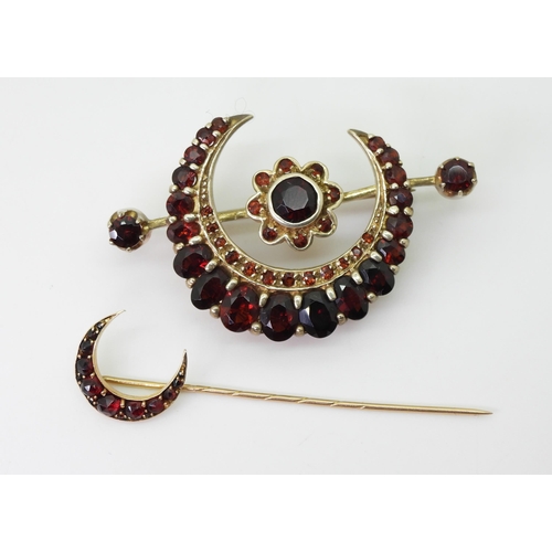 2772 - GARNET SET CRESCENT MOON BROOCHESa yellow metal garnet set crescent moon pin, length 5.5cm, weight 1... 