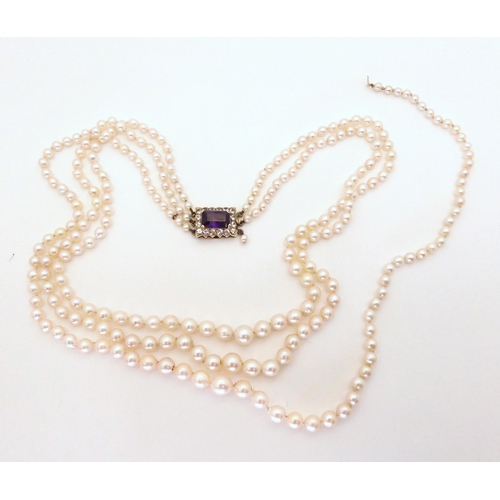 769 - A triple strand of pearls (af) with a 9ct gold amethyst and clear gem set clasp, shortest length app... 