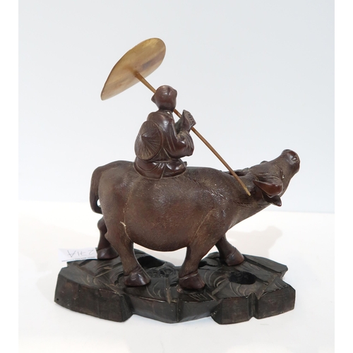 271A - A Chinese carved figure of a boy carrying a horn parasol&nbsp; riding a water buffalo, on a naturali... 