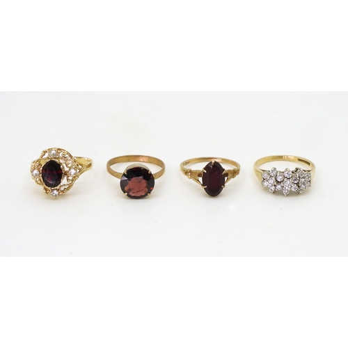 789 - A 9ct gold clear gem set cluster ring, size O, together with three 9ct and yellow metal garnet rings... 