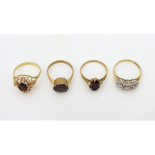 789 - A 9ct gold clear gem set cluster ring, size O, together with three 9ct and yellow metal garnet rings... 