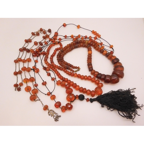 804 - A collection of amber coloured beads, to include two vintage flapper length necklaces, large stateme... 