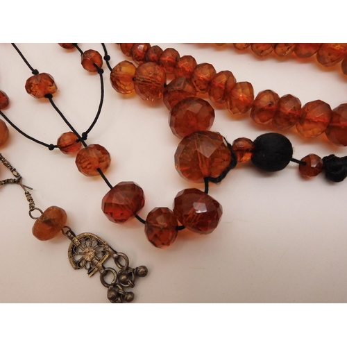 804 - A collection of amber coloured beads, to include two vintage flapper length necklaces, large stateme... 