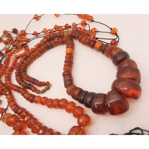 804 - A collection of amber coloured beads, to include two vintage flapper length necklaces, large stateme... 