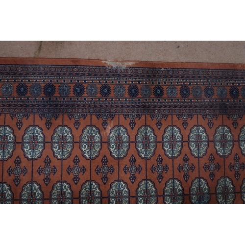 124 - A pair of terracotta ground Bokhara rugs with all over lozenge design and multicoloured border, 364c... 