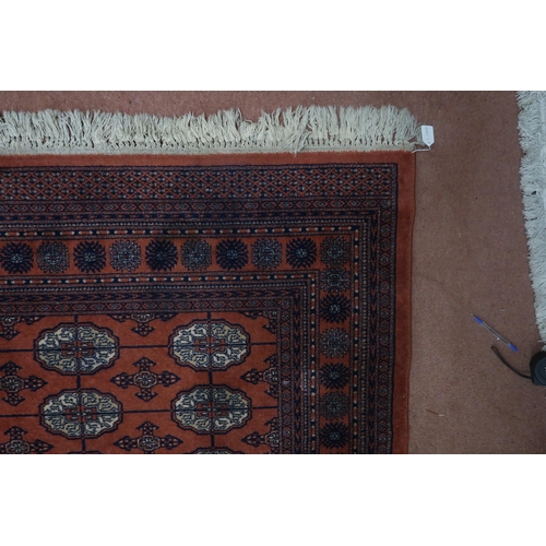 124 - A pair of terracotta ground Bokhara rugs with all over lozenge design and multicoloured border, 364c... 