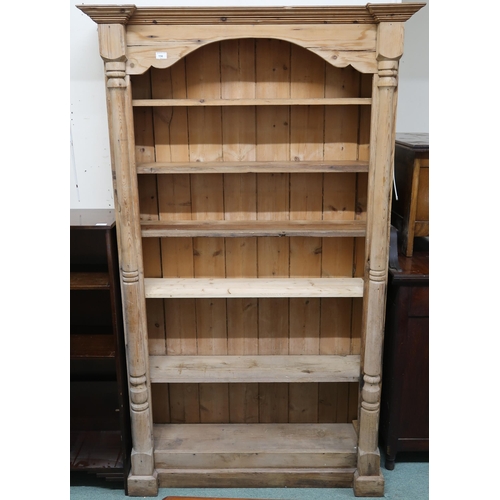 156 - A 20th century pine open bookcase with moulded cornice over five adjustable shelves flanked column r... 