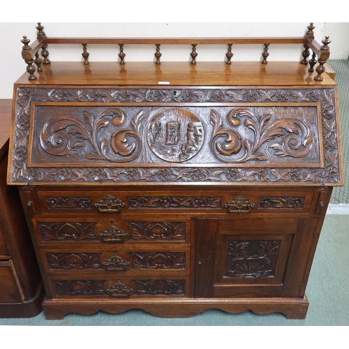 159 - A 20th century oak writing bureau with galleried top over extensively carved writing slope concealin... 