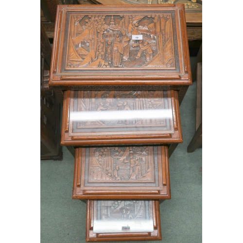 19 - A 20th century Chinese hardwood nest of four tables with each top carved with village scenes, 67cm h... 