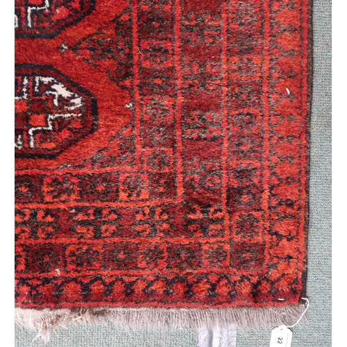 22 - A red ground Bokhara rug with lozenge design and multiple borders, 140cm long x 109cm wide 